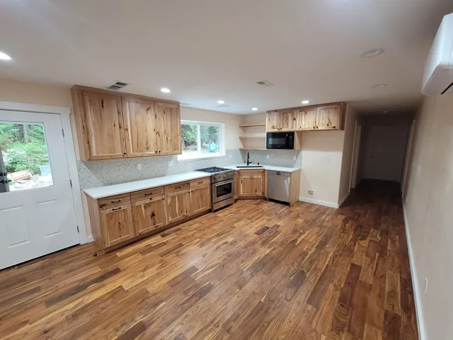 Newly renovated kitchen with wood cabinets, stainless steel appliances, and hardwood floors.